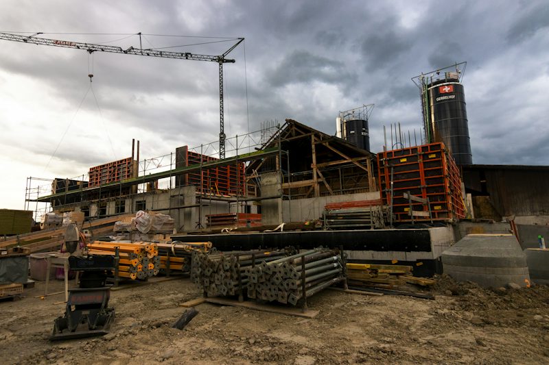 Construction site with stacked formwork, props and a tower crane